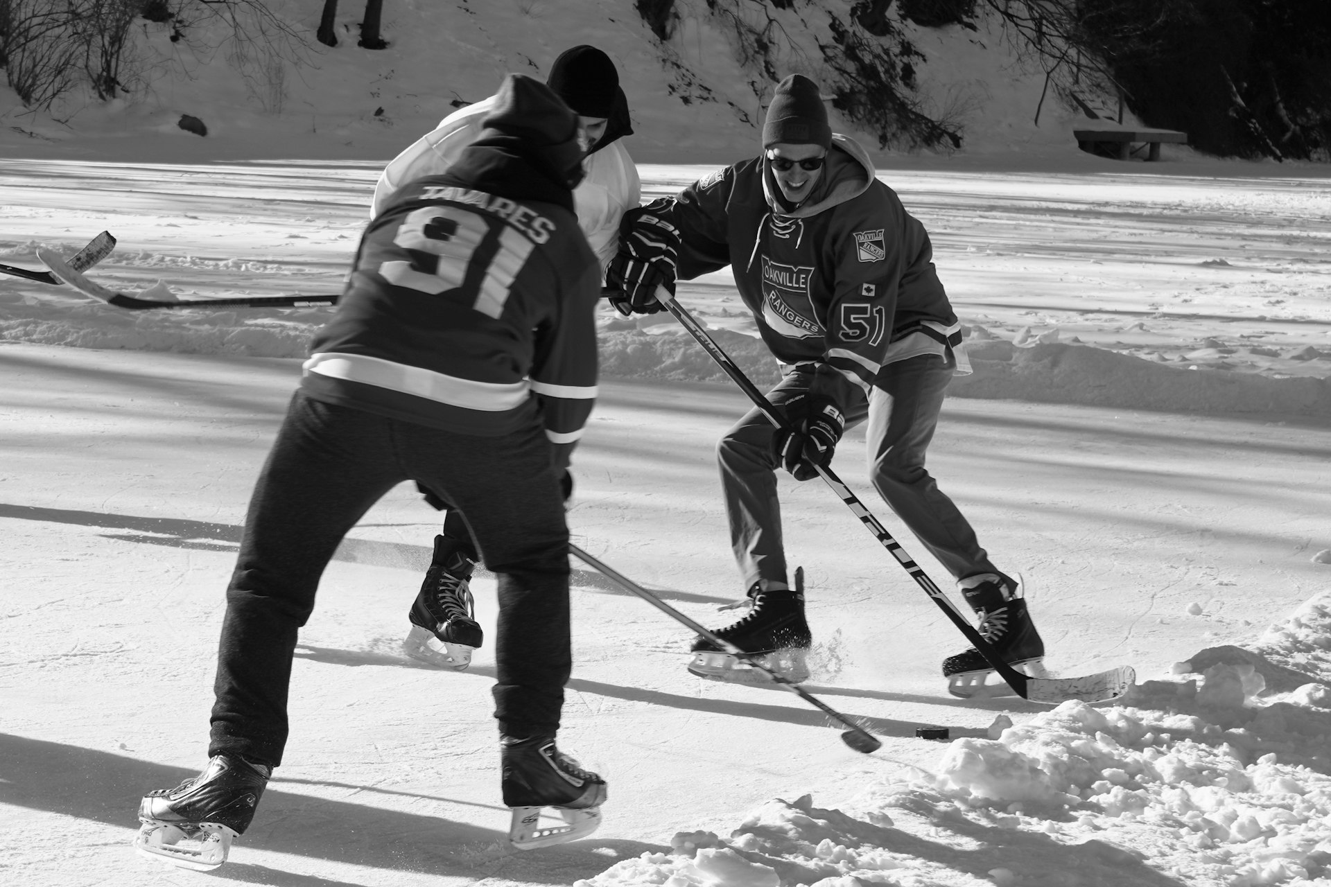 a couple of men riding skis across snow covered ground